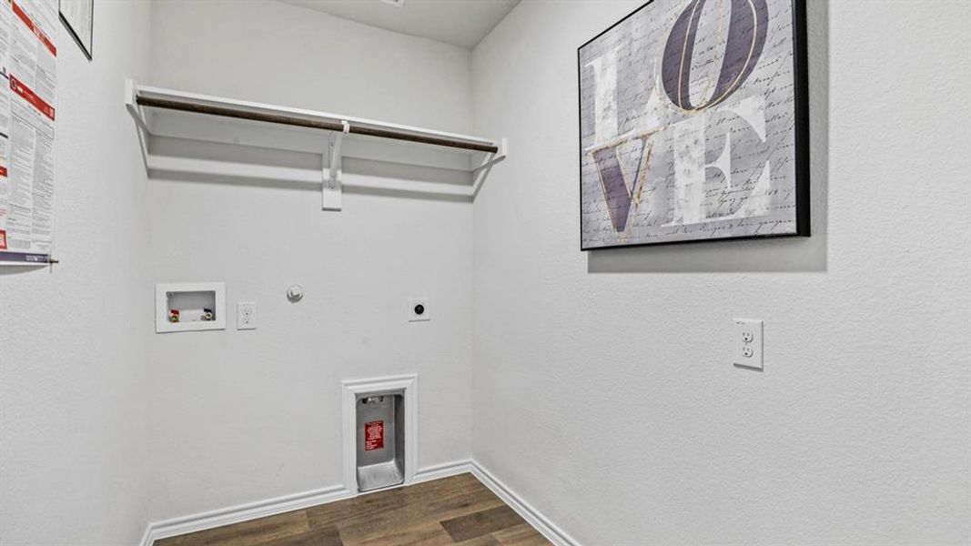 Dedicated utility space featuring wood-finish flooring, white walls, and a built-in hanging rod