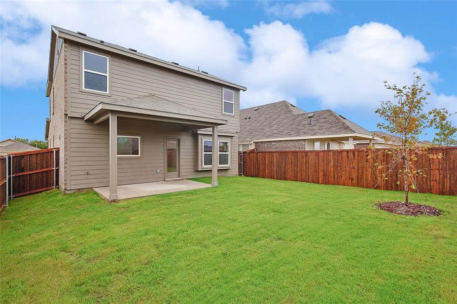 Rear view of house with a lawn and a patio area