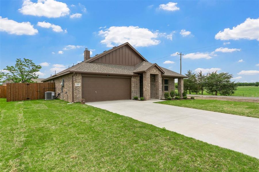 Brick exterior with a prominent two-car garage, concrete driveway, and covered front entry