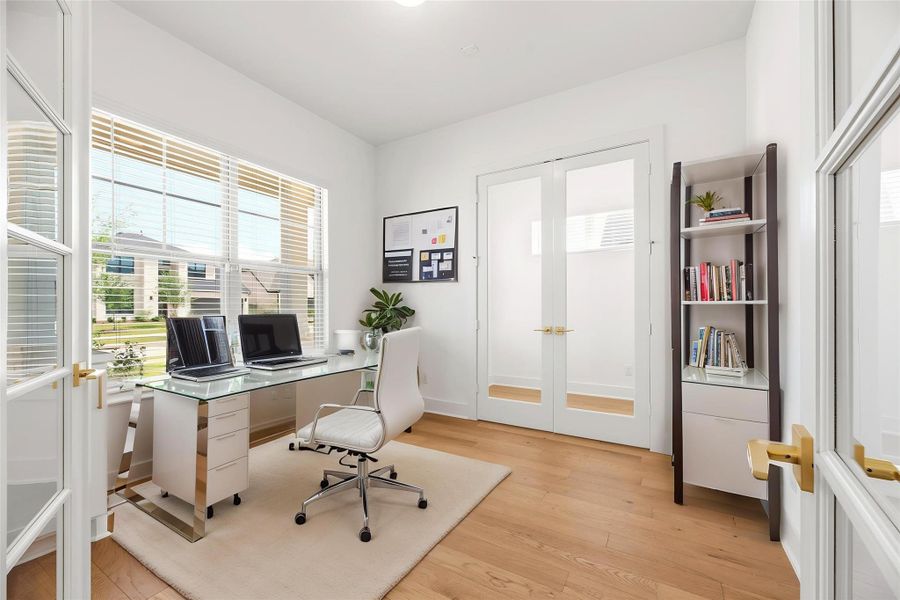 Featuring elegant French doors and engineered wood flooring, this private study offers a quiet, sun-drenched workspace ideal for productivity or focused work. Virtually staged.