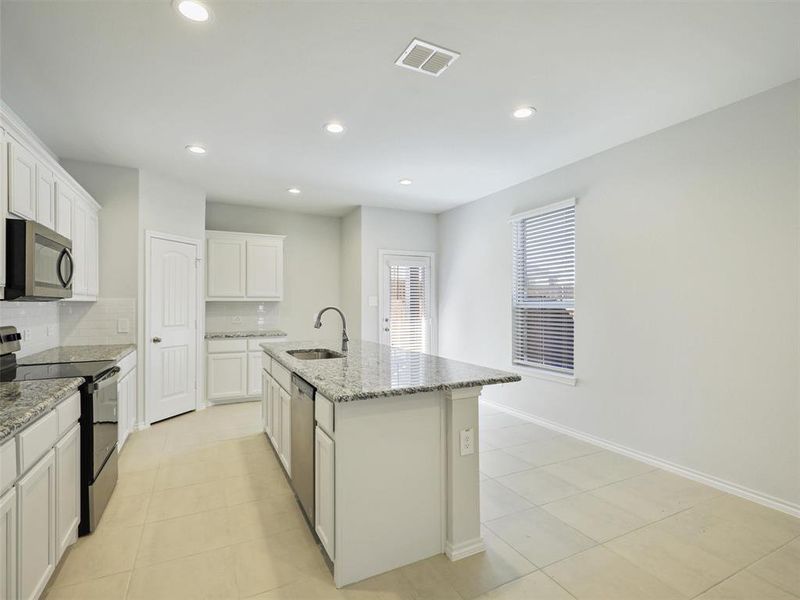 Kitchen featuring a sink, tasteful backsplash, visible vents, light stone counters, and appliances with stainless steel finishes Kitchen featuring a sink, tasteful backsplash, visible vents, light stone counters, and appliances with stainless steel finishes