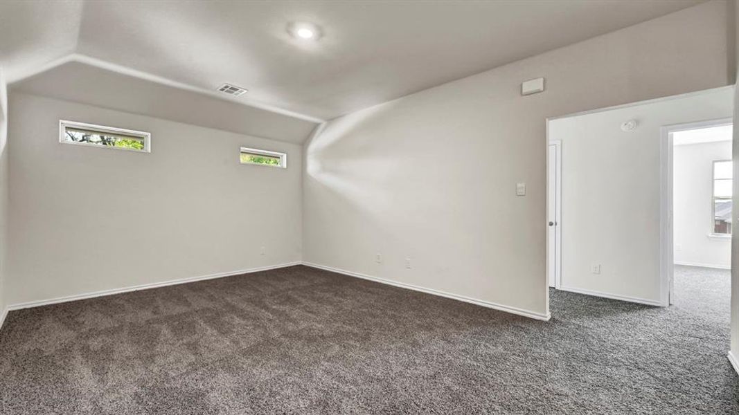 Spacious room featuring neutral carpeting and light-colored walls