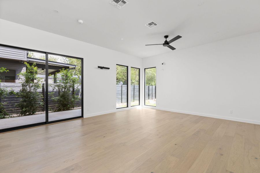 Empty room with light wood-style floors and ceiling fan