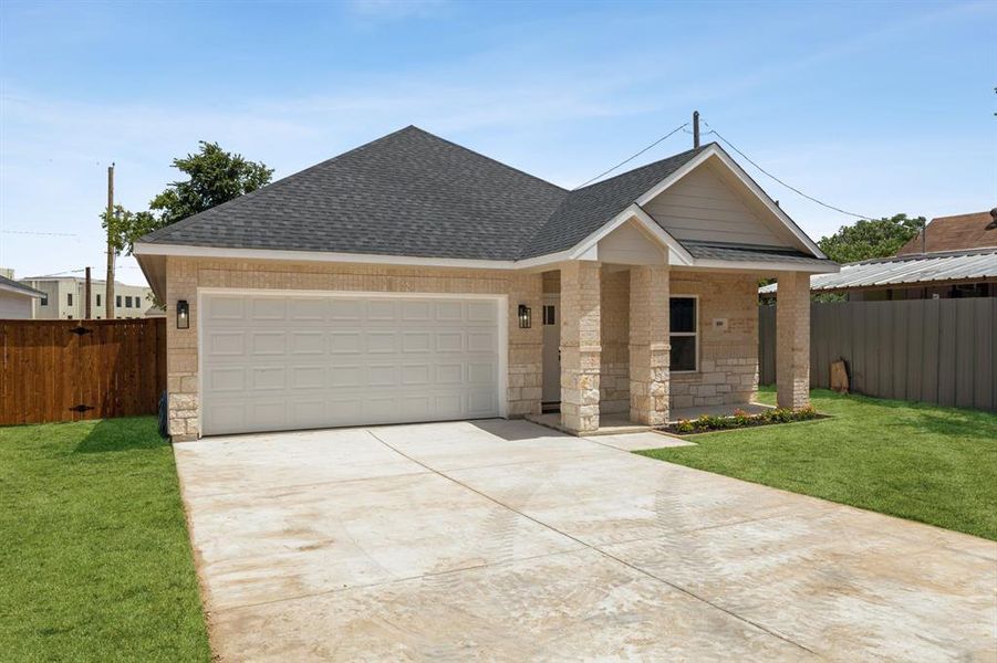 View of front of property with a garage and a front yard