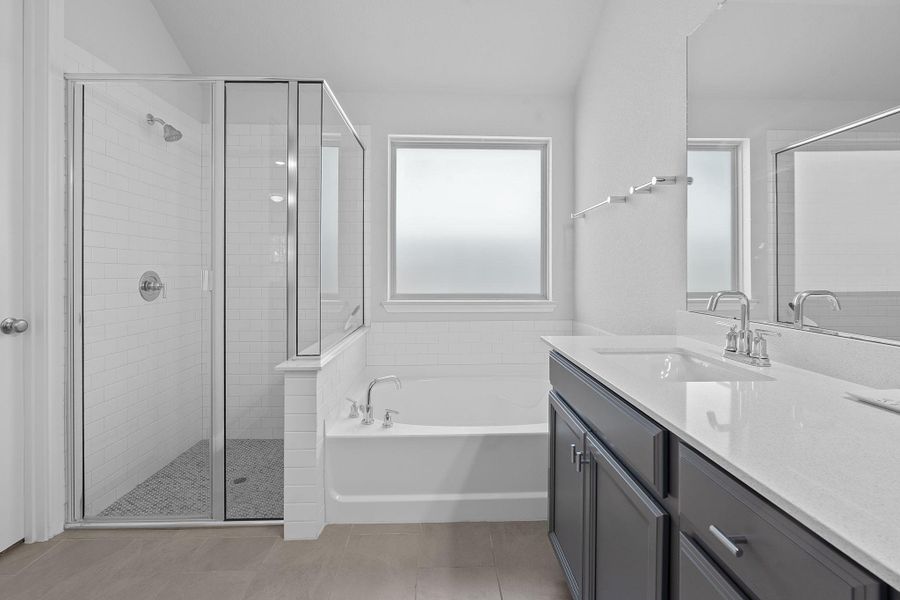 Full bath with vanity, a shower stall, a bath, and light tile patterned floors Full bath with vanity, a shower stall, a bath, and light tile patterned floors