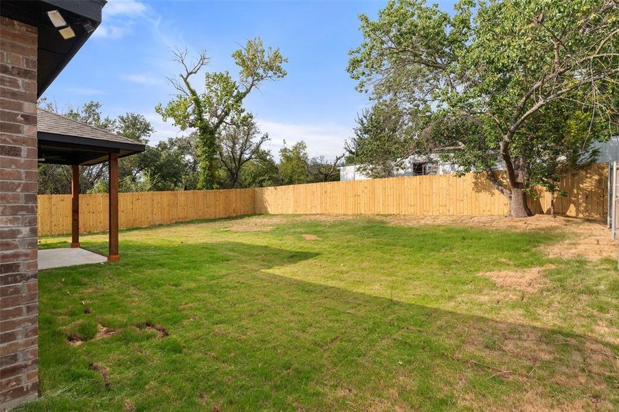 Fenced backyard with a patio area