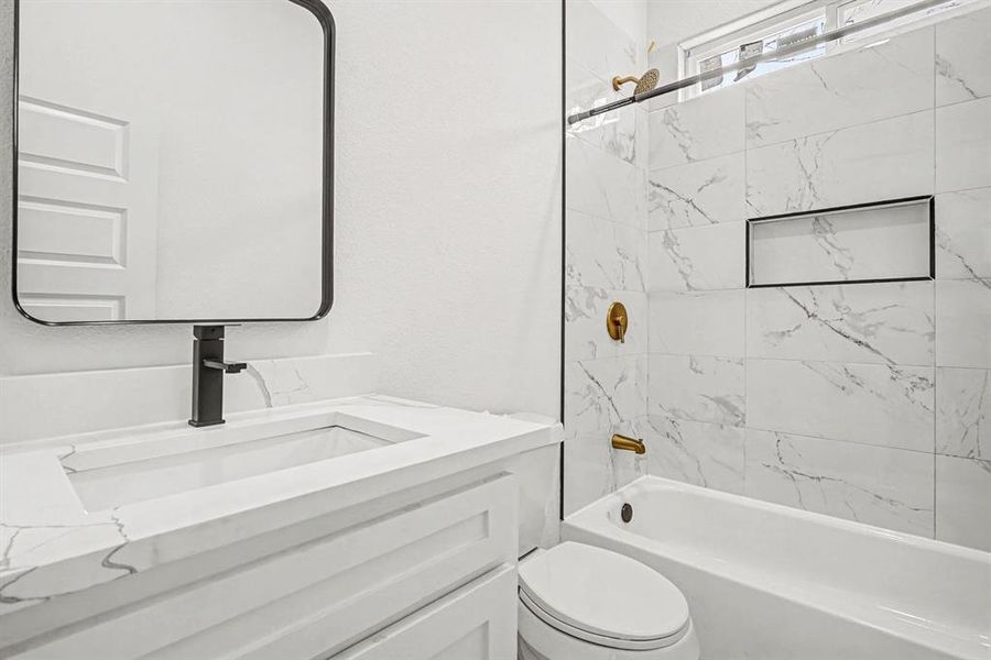 Secondary bathroom with tub / shower combination and vanity, built-in cabinets, dimmable mirrored lighting.
