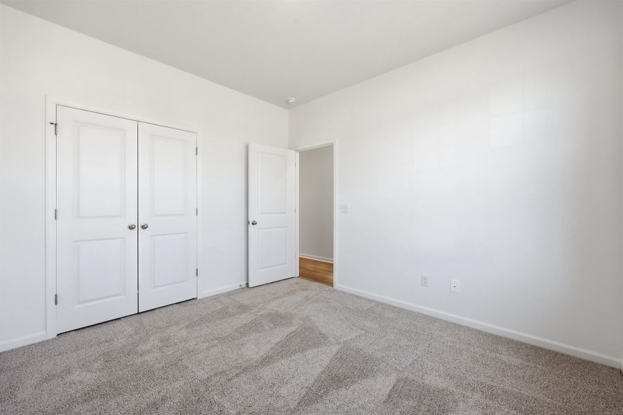 Unfurnished bedroom featuring carpet flooring and a closet Unfurnished bedroom featuring carpet flooring and a closet