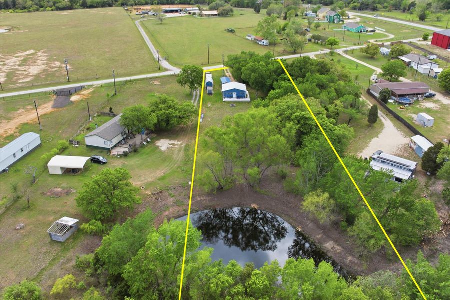 Aerial view of property and surrounding area featuring property parcel outlined and a nearby body of water