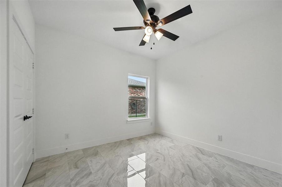 Empty room with ceiling fan and baseboards