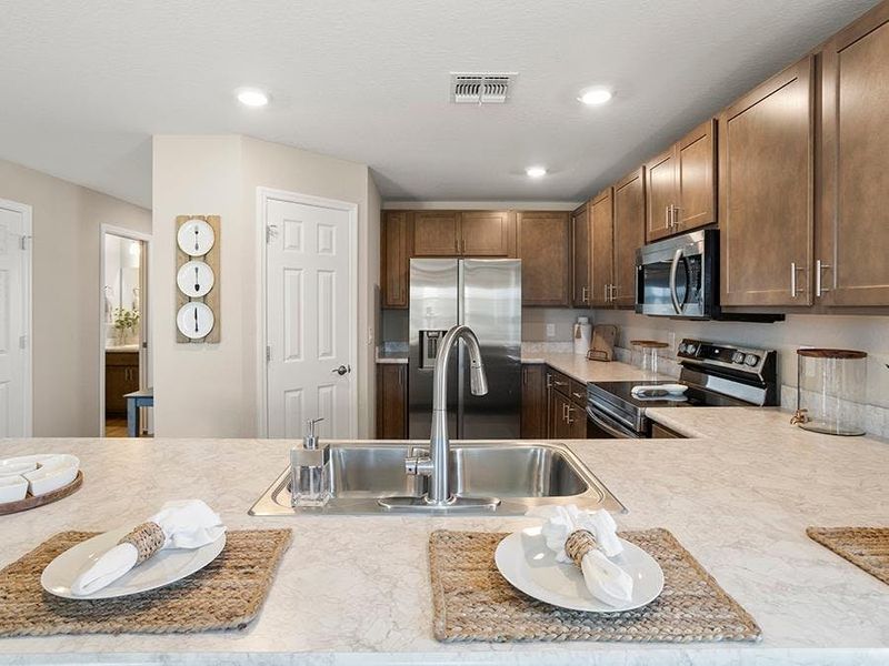 Your bright, open kitchen includes modern conveniences and in-kitchen dining at the bar - Isla townhome by Highland Homes