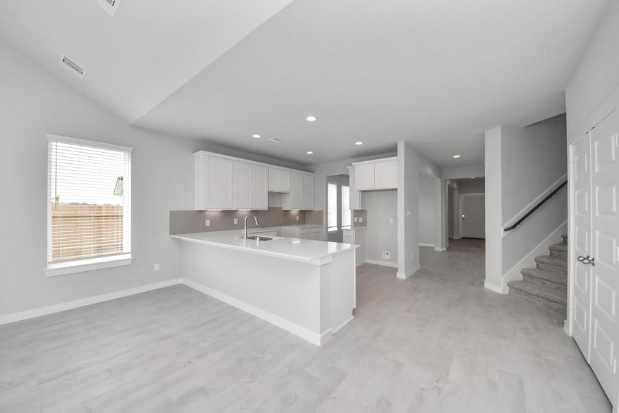 Step into a dream realized with this generously spacious kitchen! A massive granite island takes center stage, complemented by high ceilings and soft-close cabinets. The granite countertops, stainless steel appliances, sleek tile backsplash, and recessed lighting complete the elegant design. Sample photo of completed home with similar floor plan. Actual colors and selections may vary. Step into a dream realized with this generously spacious kitchen! A massive granite island takes center stage, complemented by high ceilings and soft-close cabinets. The granite countertops, stainless steel appliances, sleek tile backsplash, and recessed lighting complete the elegant design. Sample photo of completed home with similar floor plan. Actual colors and selections may vary.