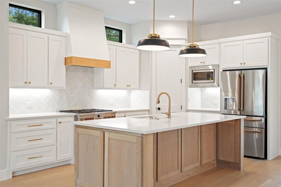 A well-appointed kitchen features a large center island, gleaming countertops, and modern appliances. A well-appointed kitchen features a large center island, gleaming countertops, and modern appliances.