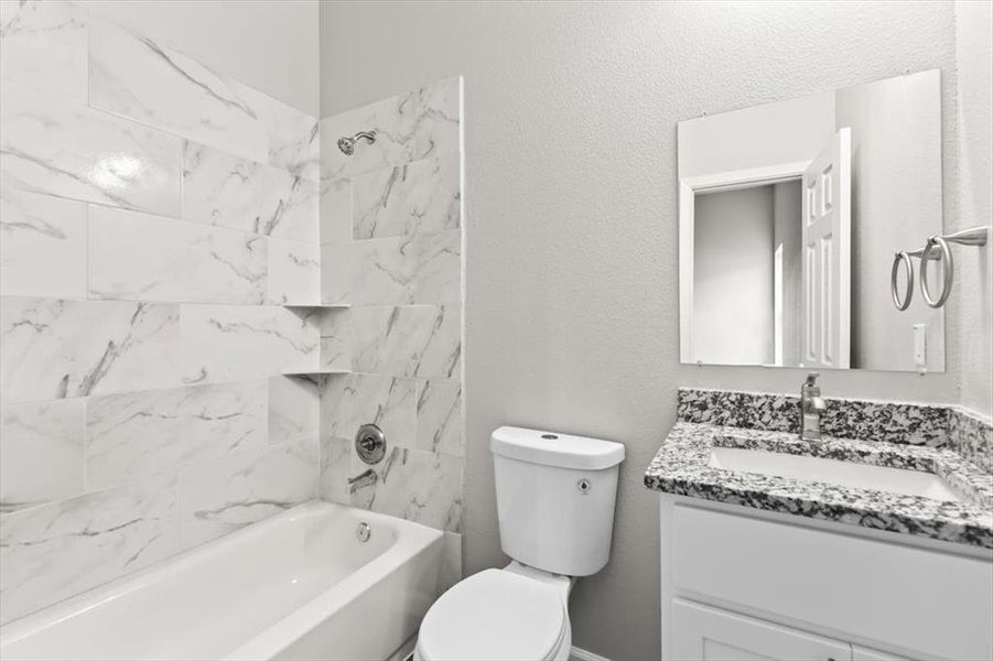 Full bathroom featuring vanity, toilet, and tiled shower / bath