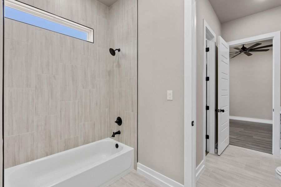 A well-lit bathroom features a deep tub and a clean, tiled shower enclosure. A well-lit bathroom features a deep tub and a clean, tiled shower enclosure.