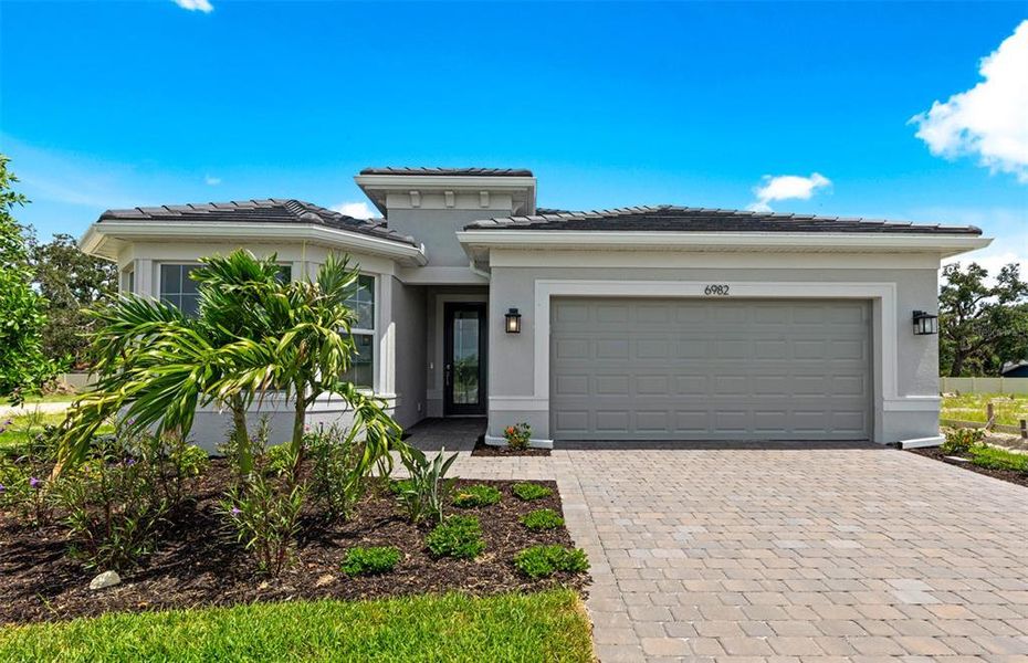 Front exterior of a new home in Legacy Groves, Nokomis, FL, highlighting curb appeal (Image 1).