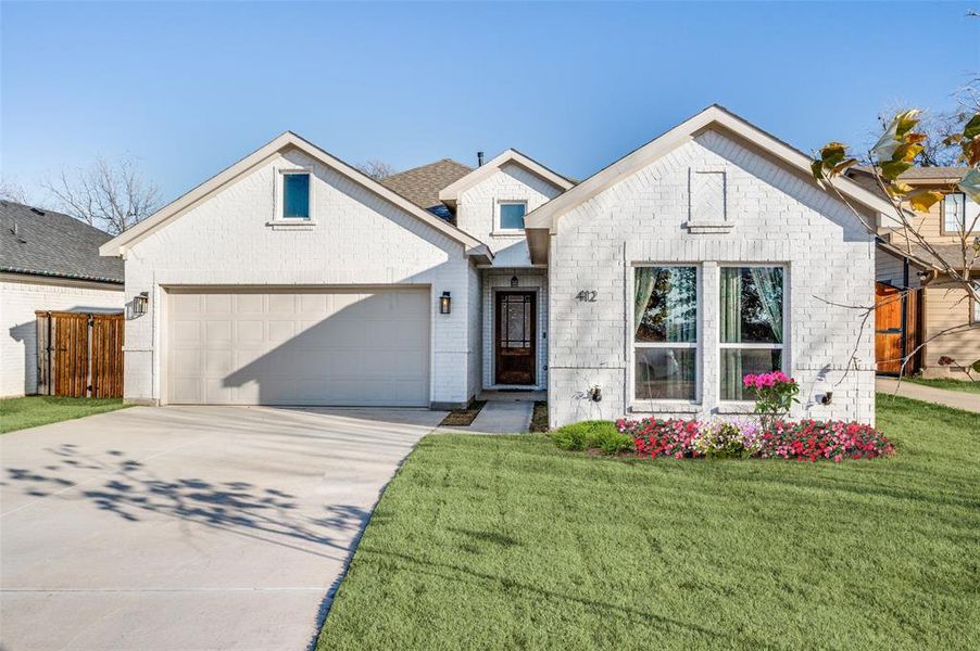 View of front of house featuring a garage and a front lawn