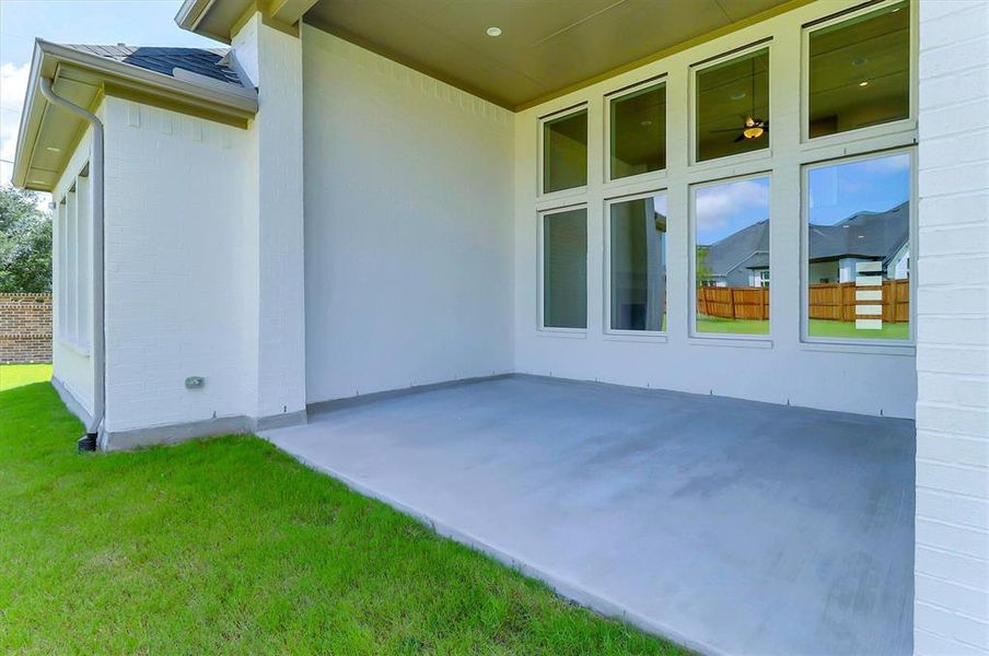 Spacious covered patio with concrete flooring, framed by white brick exterior walls Spacious covered patio with concrete flooring, framed by white brick exterior walls