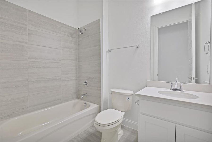 Full bathroom featuring toilet, tiled shower / bath, and vanity