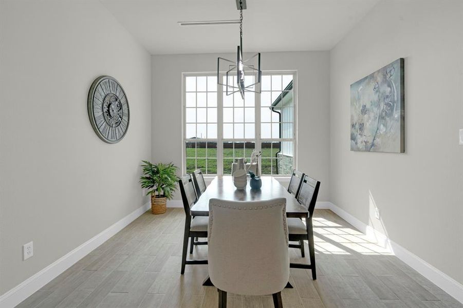 Dining space featuring light wood-type flooring and a notable chandelier