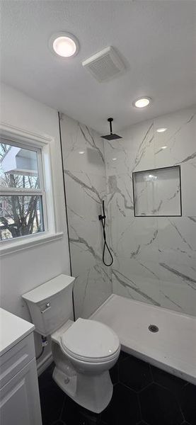 Full bathroom with a marble finish shower and vanity