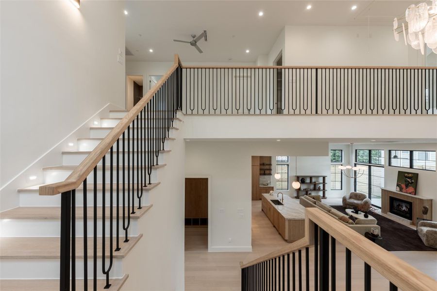 From the second floor, the open railing offers a dramatic overlook into the kitchen and living spaces below, showcasing the home’s scale and architectural connectivity from a new perspective. From the second floor, the open railing offers a dramatic overlook into the kitchen and living spaces below, showcasing the home’s scale and architectural connectivity from a new perspective.