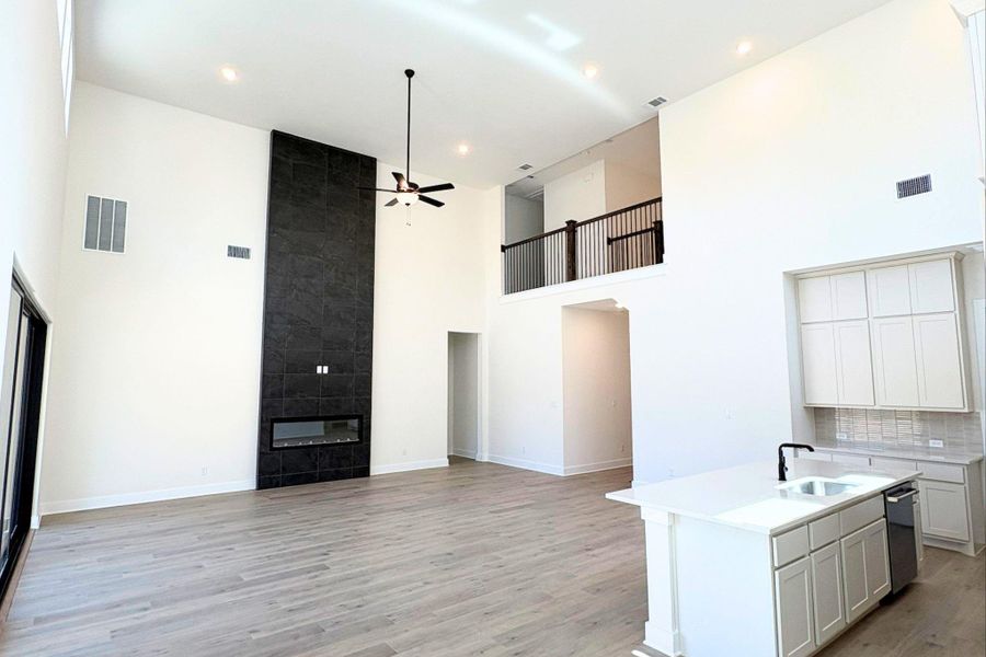 Hardwood floors and a towering tile fireplace anchor the light-filled two-story living area. Hardwood floors and a towering tile fireplace anchor the light-filled two-story living area.