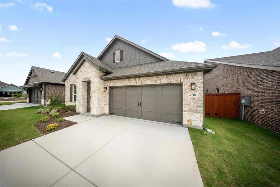 French country style house featuring roof with shingles, driveway, an attached garage, and a front lawn