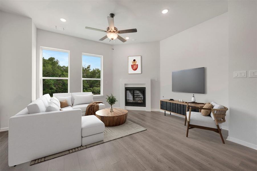 Spacious living area featuring wood-finish flooring, a contemporary fireplace, and recessed lighting Spacious living area featuring wood-finish flooring, a contemporary fireplace, and recessed lighting