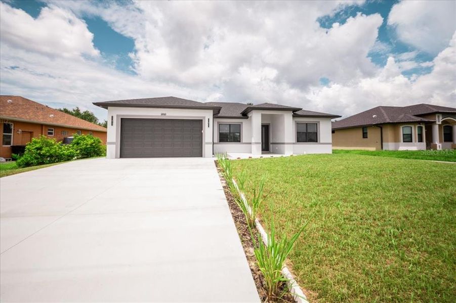 Front exterior of a new home in , North Port, FL, highlighting curb appeal (Image 2). Front exterior of a new home in , North Port, FL, highlighting curb appeal (Image 2).