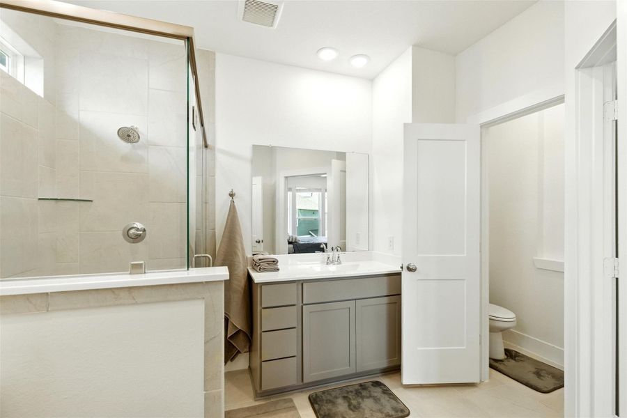 The primary bathroom features tile floors and a walk-in shower. The primary bathroom features tile floors and a walk-in shower.