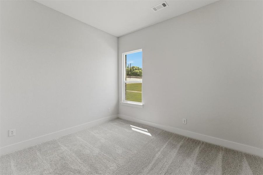 Empty room featuring light colored carpet and baseboards