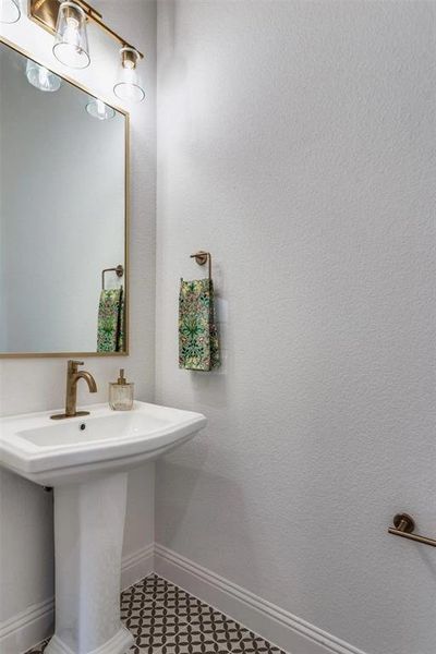 Bathroom featuring baseboards and a sink