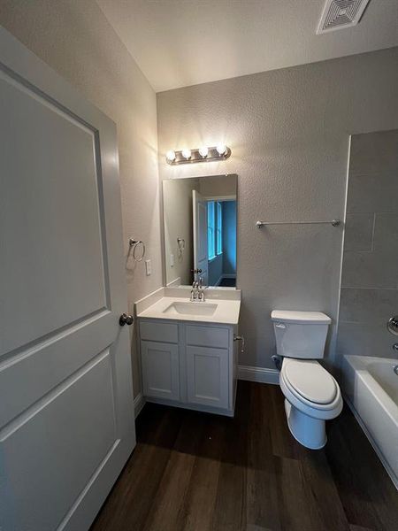 Bathroom with hardwood / wood-style flooring, vanity, and toilet