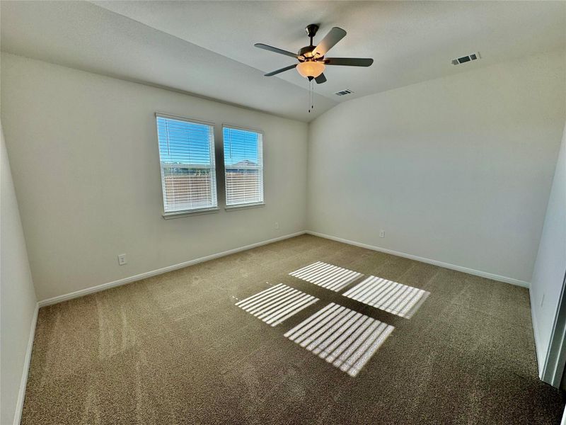 Carpeted spare room with lofted ceiling and ceiling fan
