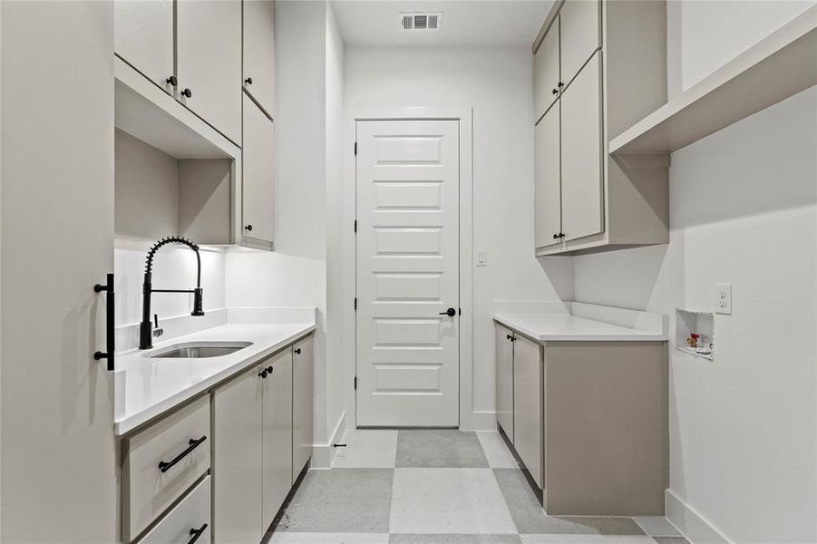 Washroom featuring cabinet space, light flooring, and hookup for a washing machine Washroom featuring cabinet space, light flooring, and hookup for a washing machine