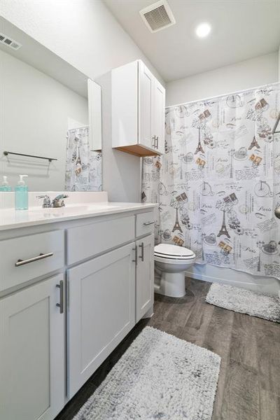 Full bathroom featuring vanity, dark wood-style floors, and shower / bath combination with curtain