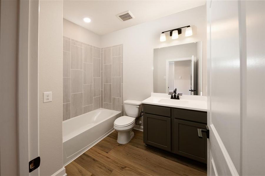 Step into the secondary bathroom, where a sleek vanity and mirror create a polished look, and the tub-shower combo ensures a tranquil space.