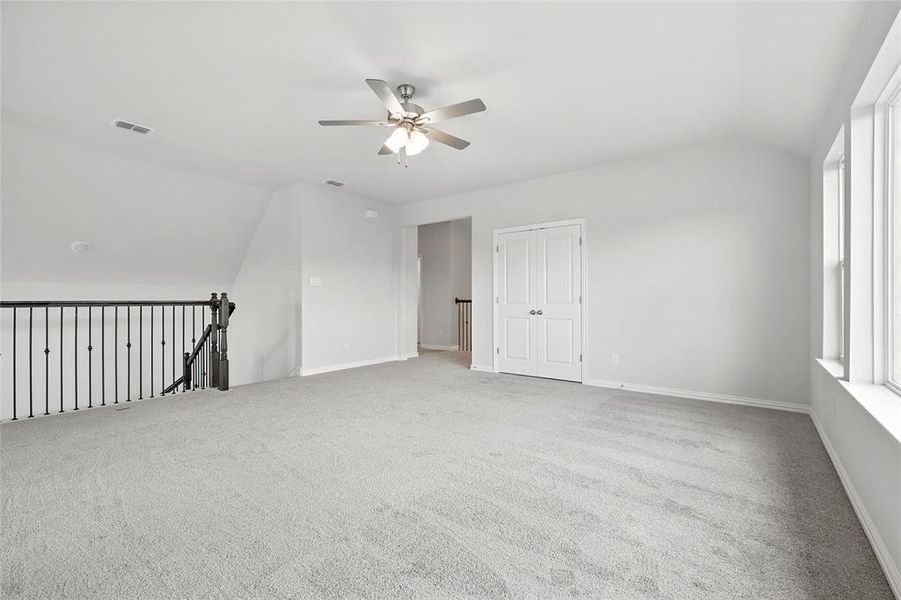 Carpeted spare room with ceiling fan and vaulted ceiling Carpeted spare room with ceiling fan and vaulted ceiling