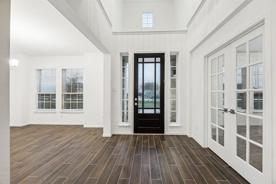 Step into elegance with this captivating front entry, featuring stunning French doors that lead into a stylish study and a beautiful leaded glass front door. The open dining area invites you to envision memorable gatherings, setting the tone for refined living in this exquisite home.