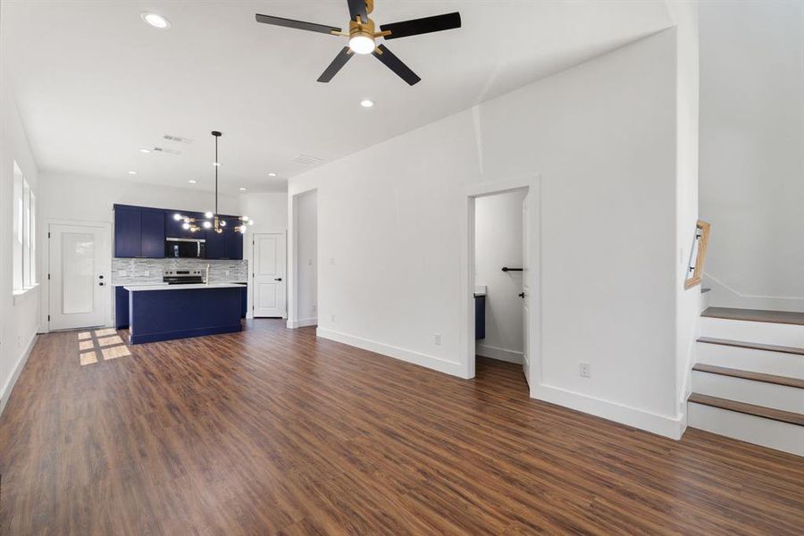 Unfurnished living room featuring dark wood-style floors, recessed lighting, stairway, and ceiling fan