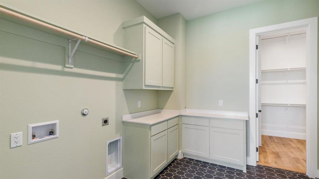 Laundry room featuring electric dryer hookup, hookup for a washing machine, dark wood-type flooring, and cabinets