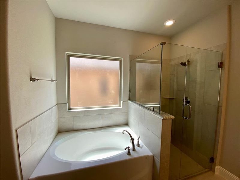 Garden tub & shower has 12x24 ceramic tile, dropped tile shower pan, and frameless glass surround Garden tub & shower has 12x24 ceramic tile, dropped tile shower pan, and frameless glass surround