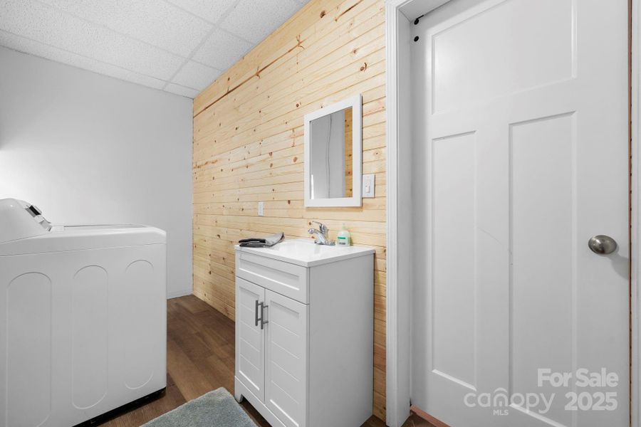 Full Bathroom with tub/ shower combo and laundry. Wood details throughout the downstairs