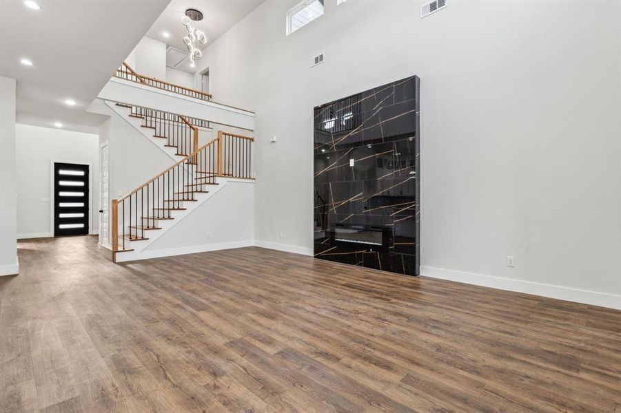 Foyer featuring a towering ceiling, a chandelier, and hardwood / wood-style flooring