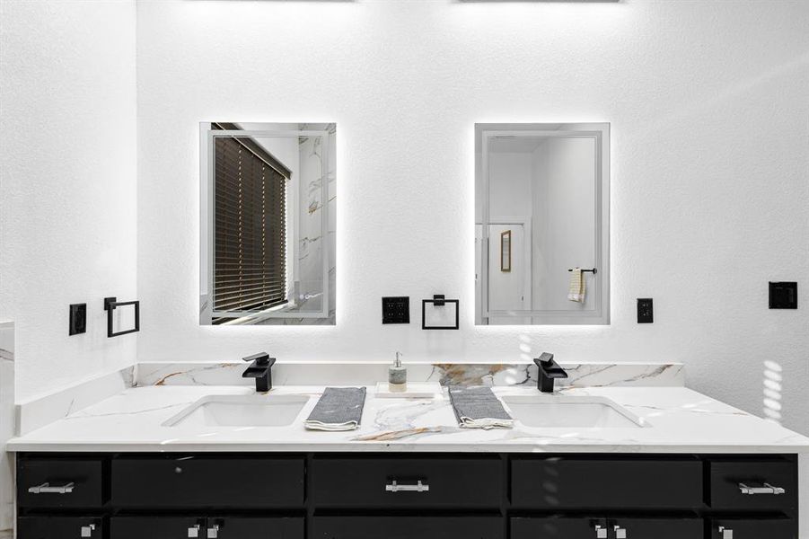 Bathroom with a textured wall and double vanity