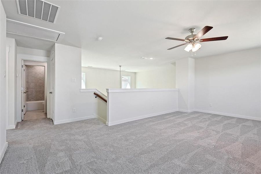 Carpeted spare room with ceiling fan