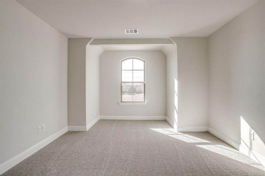 Spare room featuring light colored carpet and baseboards