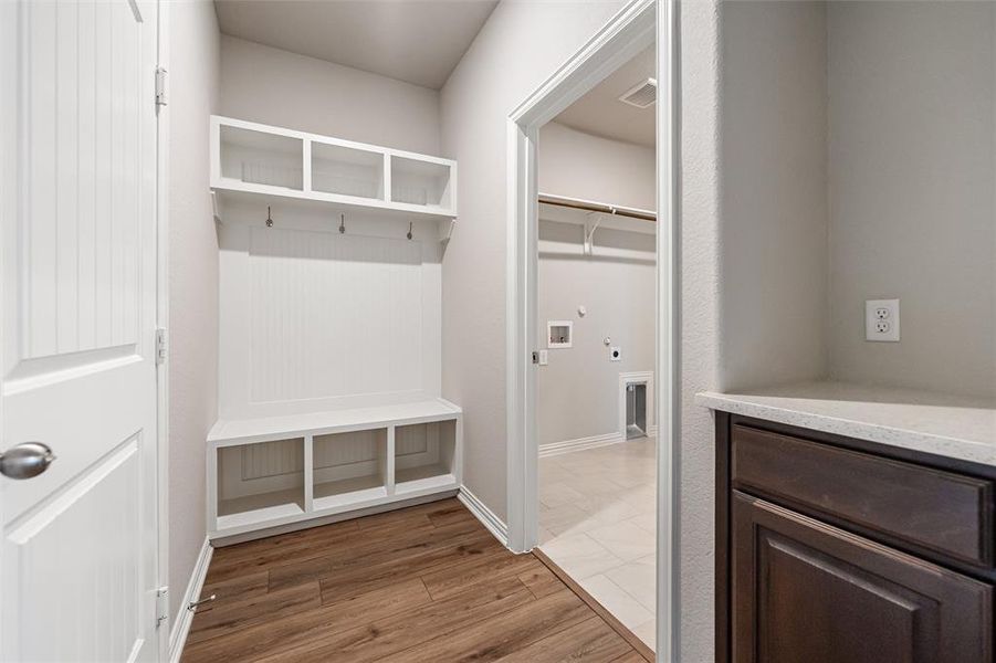 Mudroom featuring light wood-type flooring and baseboards