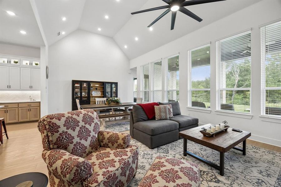 Living area with a vaulted ceiling, recessed lighting, and a modern ceiling fan Living area with a vaulted ceiling, recessed lighting, and a modern ceiling fan